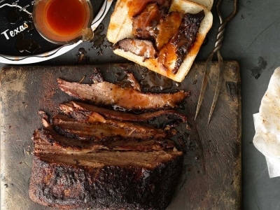 brisket half sliced with sauce on table