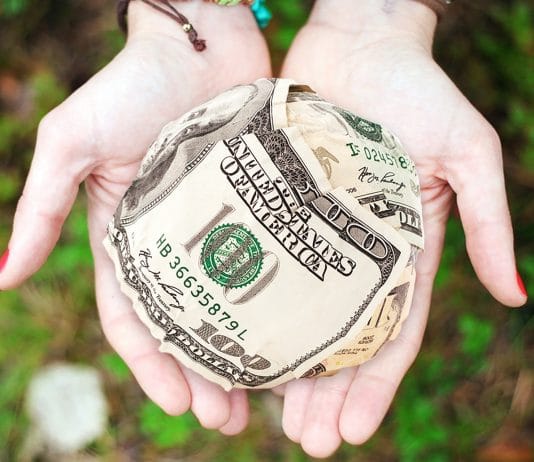 hands open together holding ball of money