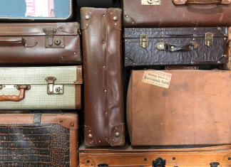 A North Texas Woman Has Gathered Nearly 100 Donated Suitcases for Foster Kids stack of used suitcases