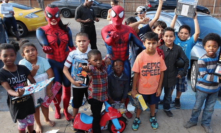 spider-man santa and a group of kids he gave gifts to