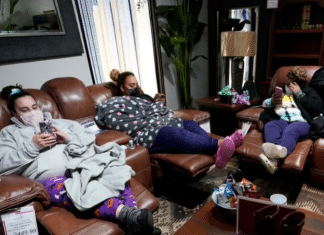 family sitting in a furniture store with masks on due to Texas winter storm