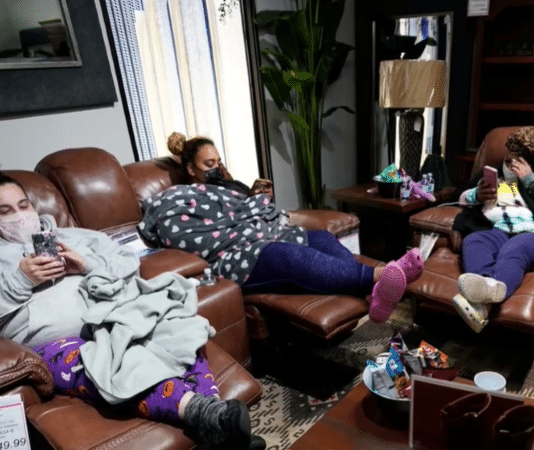 family sitting in a furniture store with masks on due to Texas winter storm