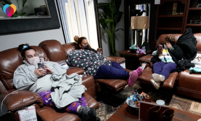 family sitting in a furniture store with masks on due to Texas winter storm