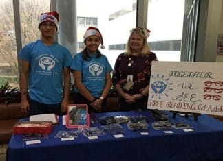 group of teens standing at a table for nonprofit Together We See