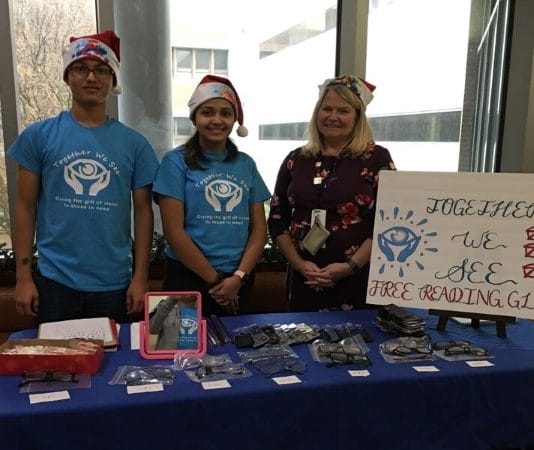 group of teens standing at a table for nonprofit Together We See