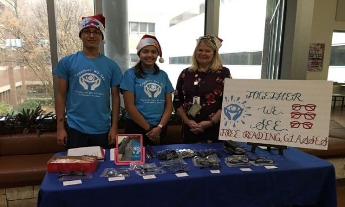 group of teens standing at a table for nonprofit Together We See