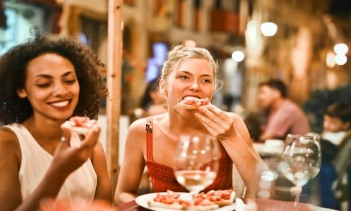 women sitting outside eating on a patio