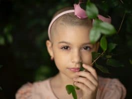 Gentle girl with short hair touching plant