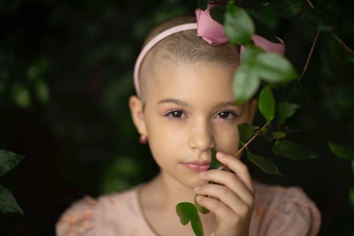 Gentle girl with short hair touching plant