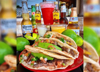 plate of tacos on a table surrounded by beer