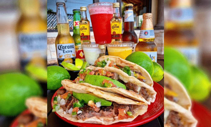 plate of tacos on a table surrounded by beer