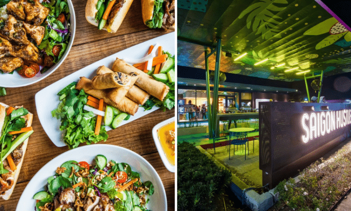 Vietnamese food on a table and Saigon Hustle neon sign on Houston patio