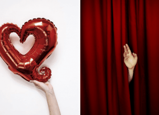 hand holding red heart balloon and hand waving through red stage curtain