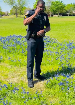 mckinney police officer roberts posing a field of bluebonnets