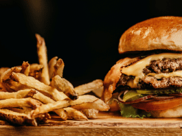 Cheeseburger and French fries on a chopping board