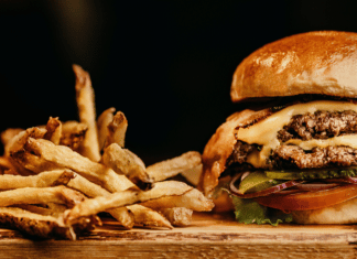 Cheeseburger and French fries on a chopping board