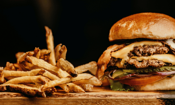 Cheeseburger and French fries on a chopping board