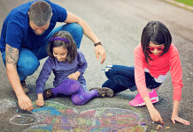 father and daughters making chalk art